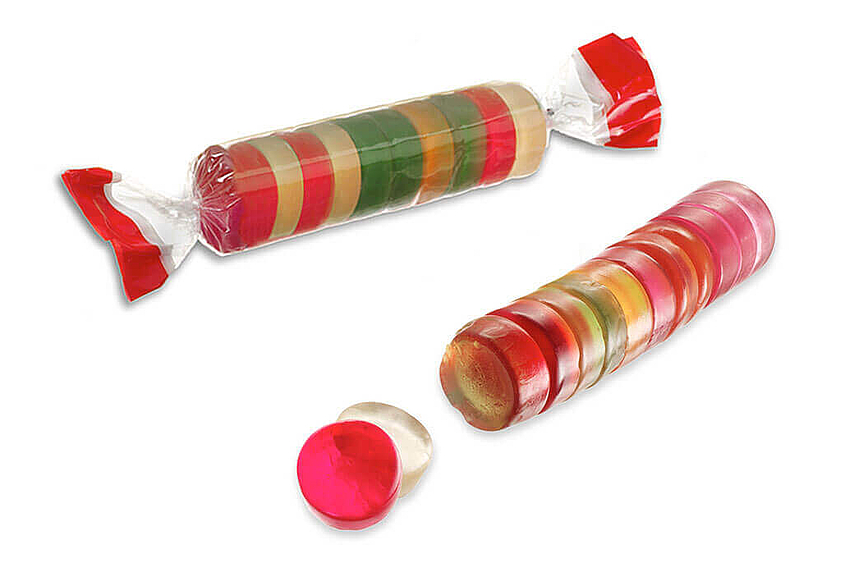Un rollo de chicles de frutas de colores sin envase y un rollo en envase transparente