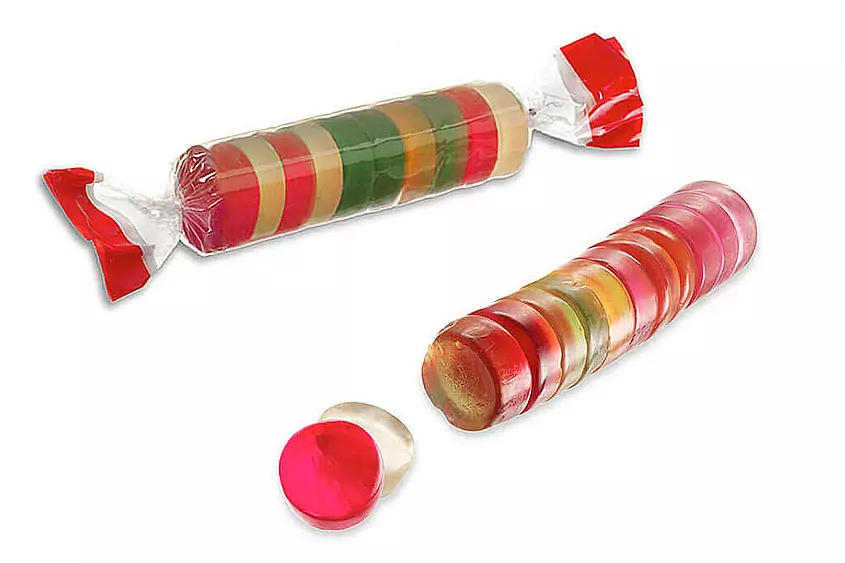 One roll of colorful fruit gums without packaging and one roll in transparent packaging