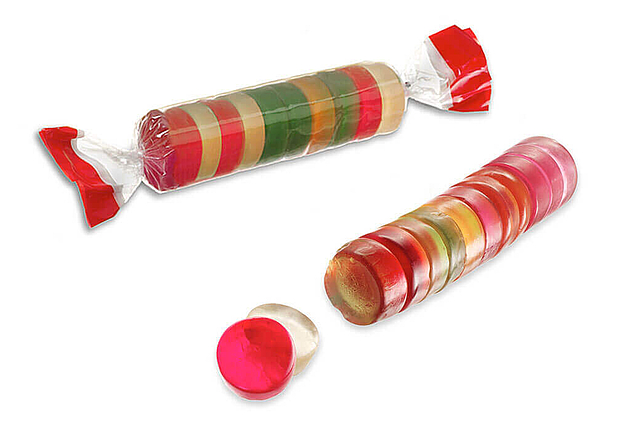Envasado para rollos de chicle de frutas Un rollo de chicles de frutas de colores sin envase y un rollo en envase transparente
