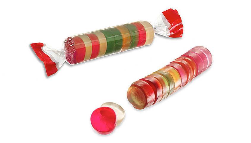 Eine Rolle bunter Fruchtgummis ohne Verpackung und eine Rolle in durchsichtiger Verpackung