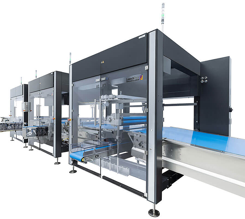Sistema de alimentación y distribución Loeschpack LOMATIC para diversos productos Vista lateral del sistema Lomatic de alimentación y distribución de tabletas y tabletas de chocolate